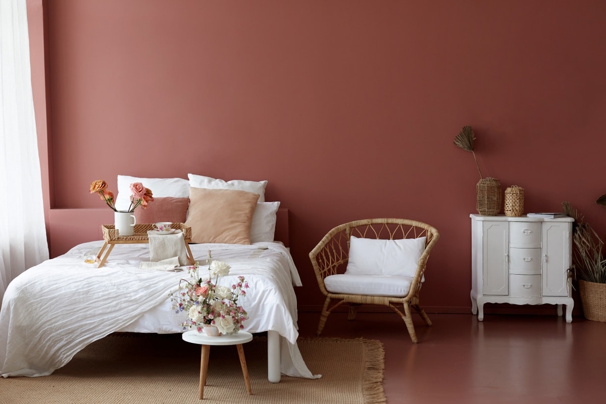 Cozy bedroom interior with retro armchair, vintage chest dwarf and bed