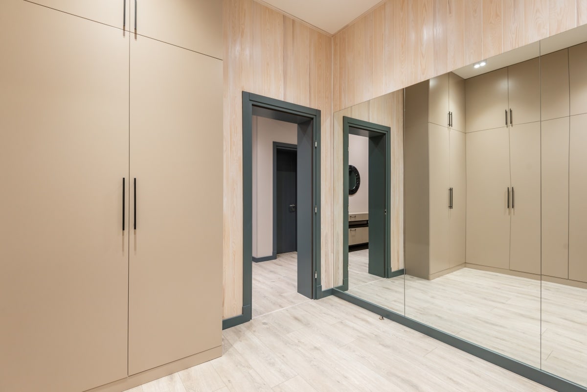 Spacious hall with closets and big mirror in apartment
