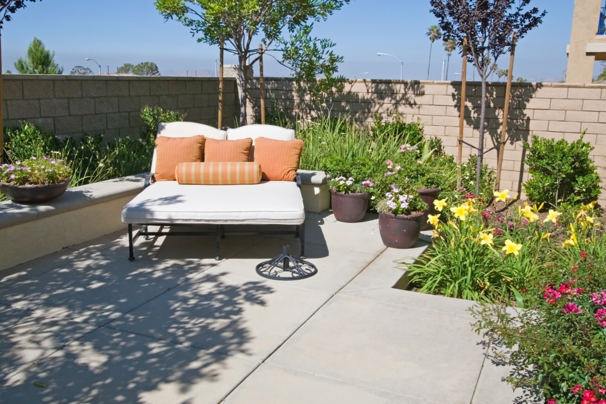 white lounge chairs with orange pillows on garden