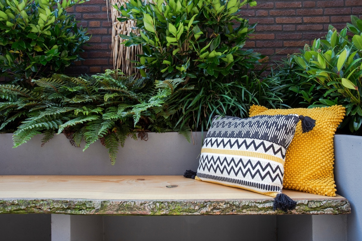 Wooden sofa with colorful pillows in cozy garden seat
