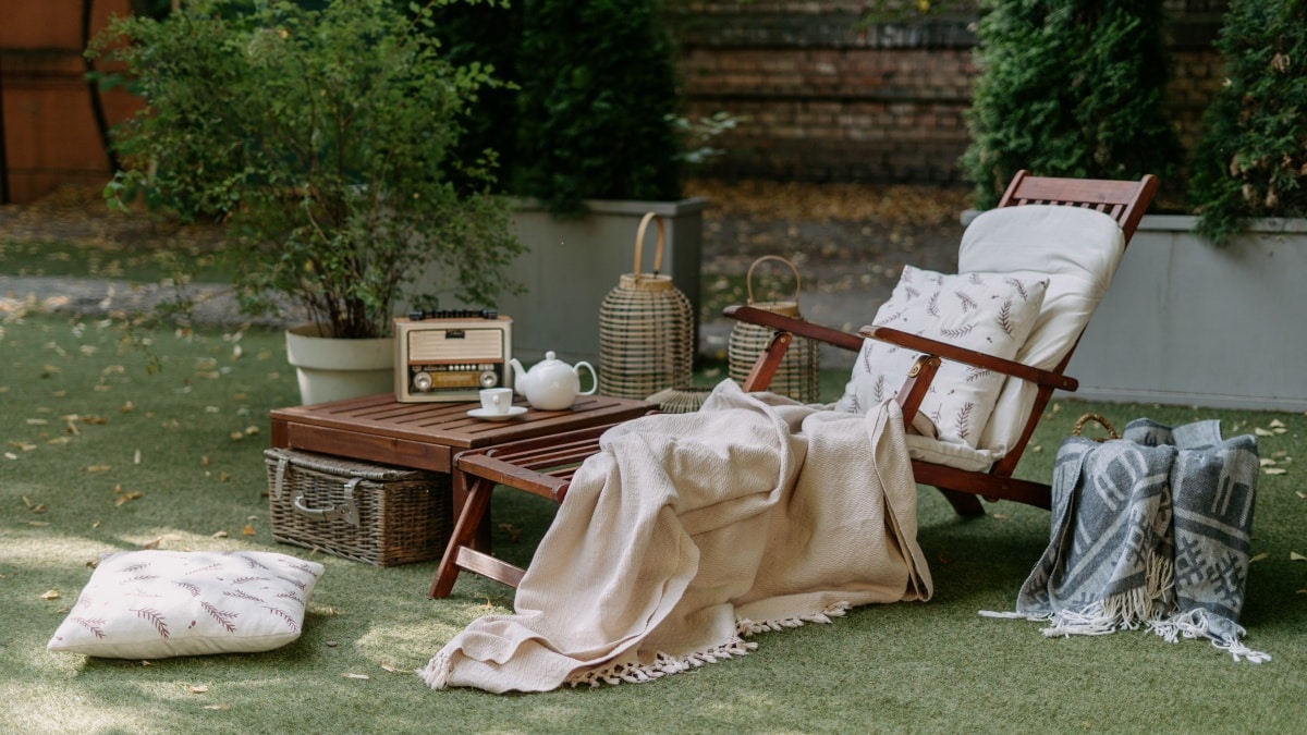 wooden lounge chair with blankets, pillows and retro, vintage decoration