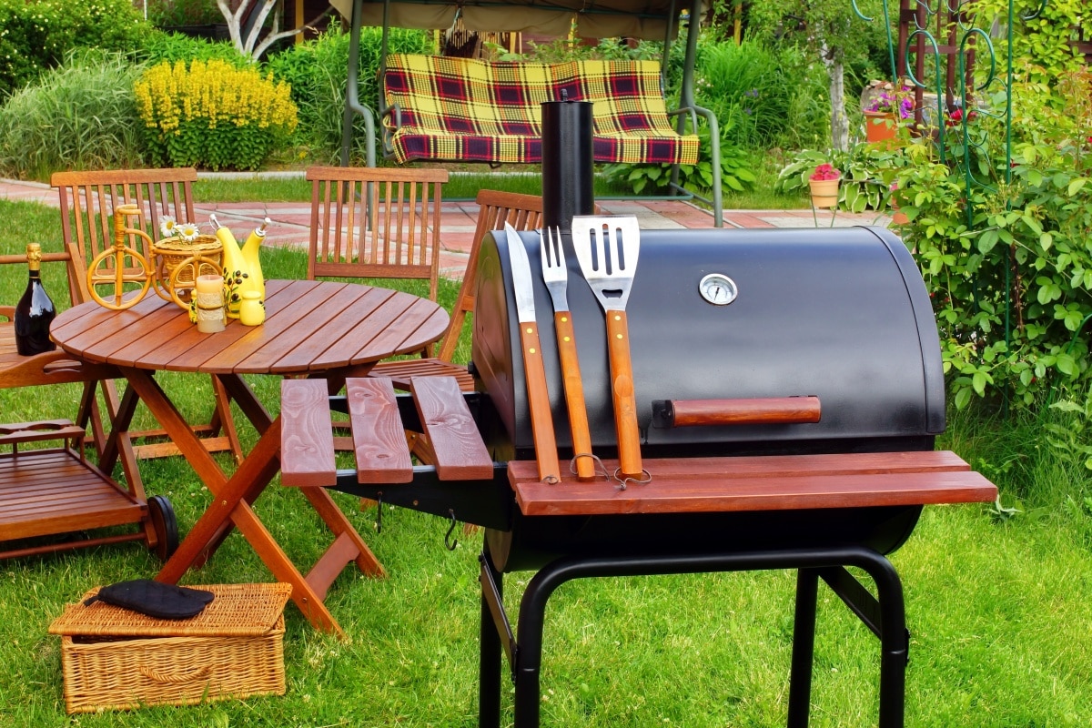 outdoor wooden dining table near a barbecue grill