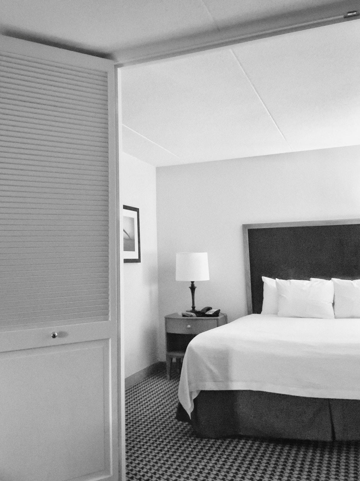 black and white bed linen on bed with black headboard