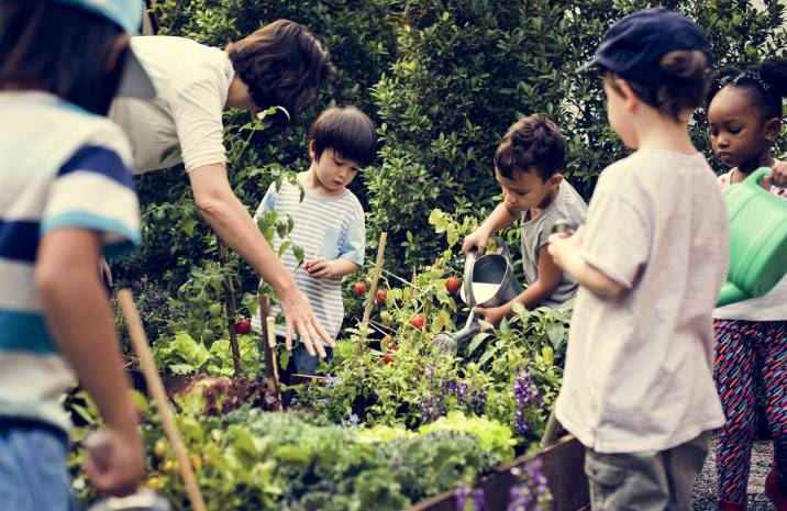 woman teaching kids a gardening class