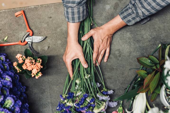 young male florist assembling cut flowers
