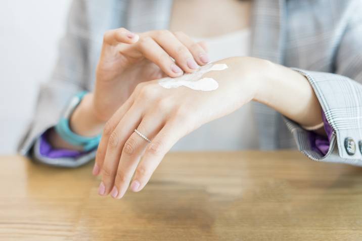 woman testing whitening essence day cream