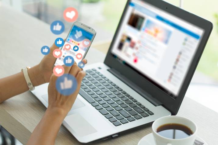 Social media manager using smartphone, responding to post comments