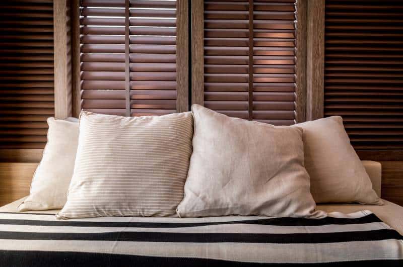 wooden blinds behind sofa, contemporary living room with part of sofa in sunny day