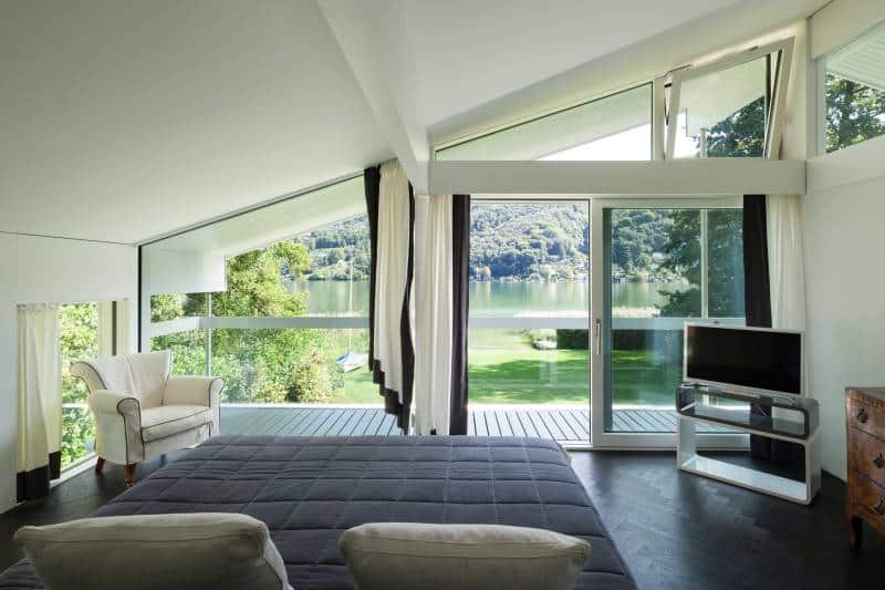 Floor-to-ceiling geometric windows. Curtains covering lower windows, upper windows with no covering to allow natural light