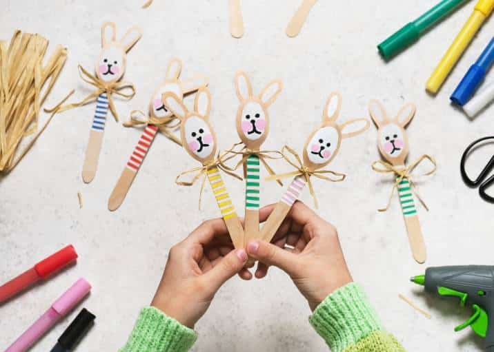 Colourful handmade Easter bunny spoons in child's hands, Easy kids crafts