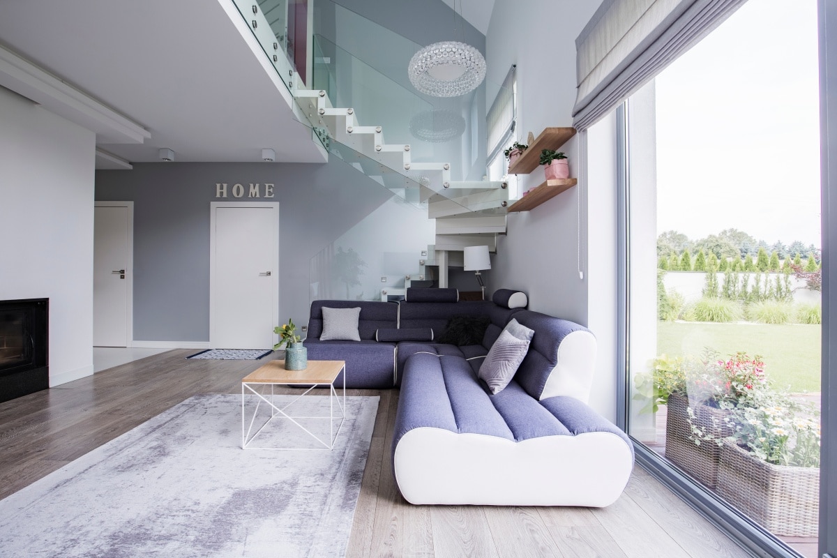 Corner sofa and coffee table under stairs in an elegant living room interior
