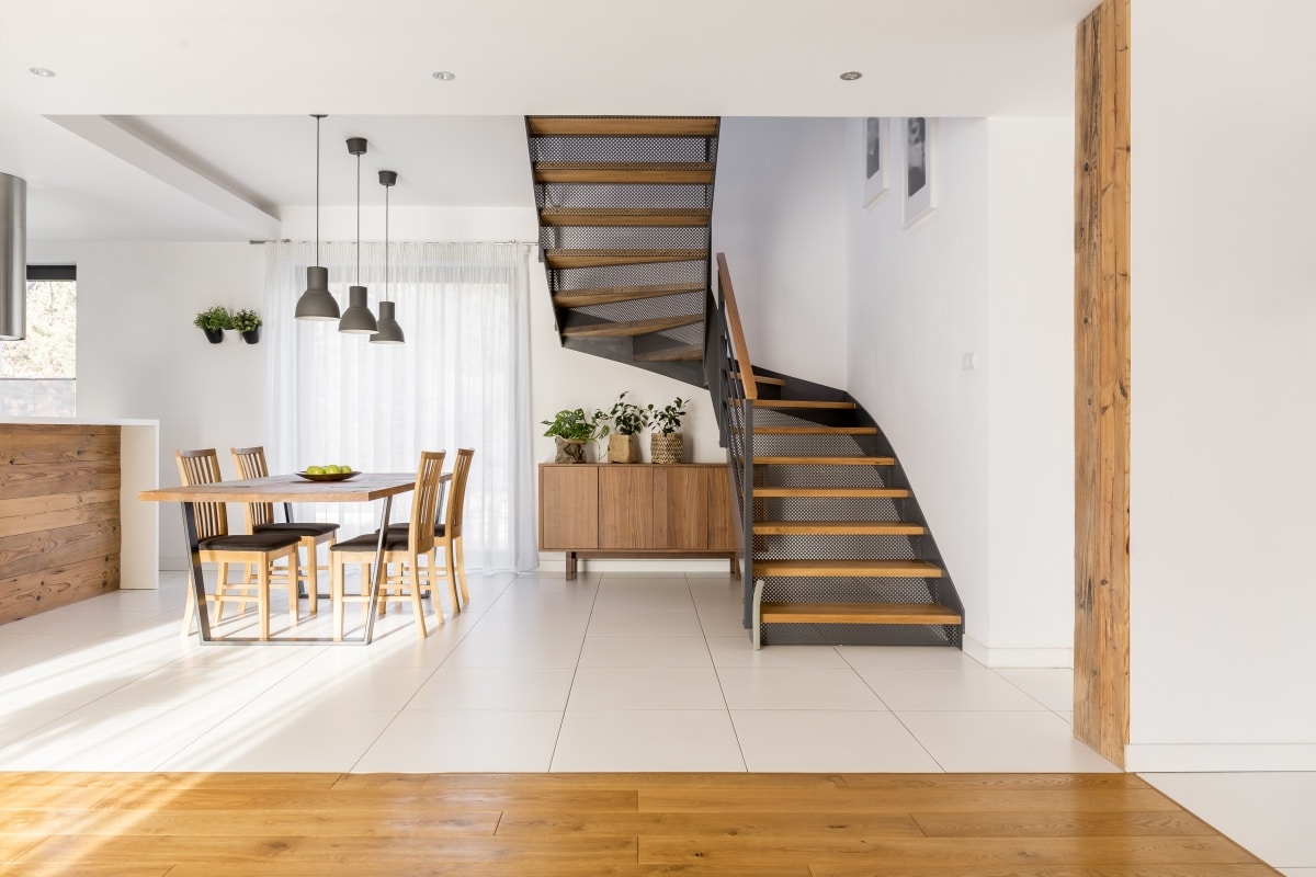 Open space with industrial half-landing stairs and wooden dining area