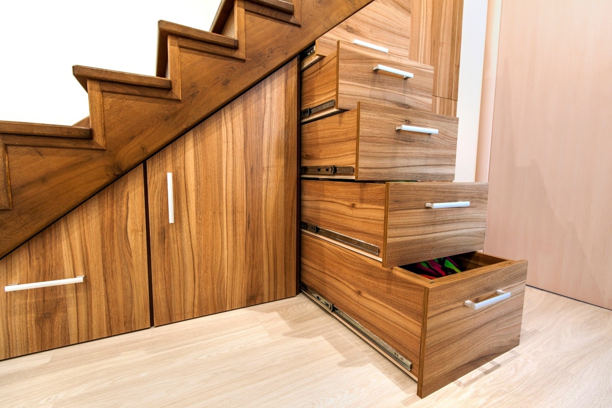 Custom built pullout cabinets on glides in slots under stairs