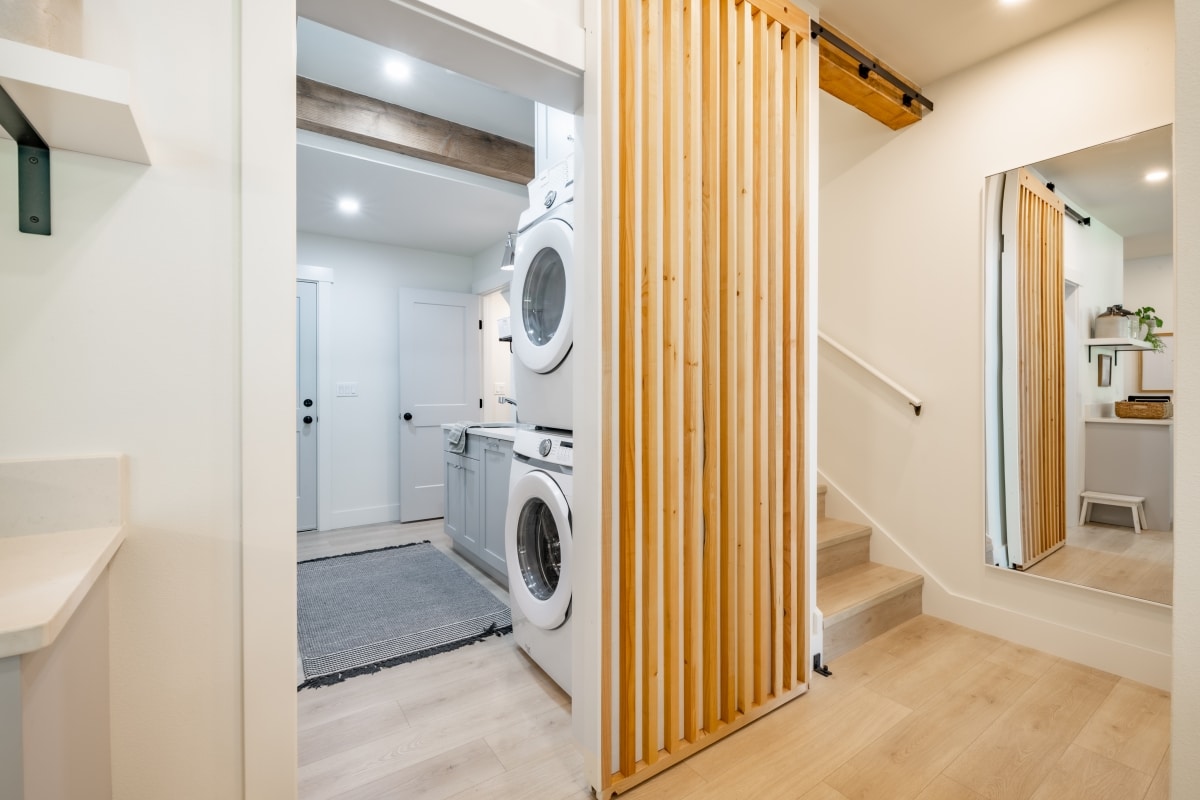 laundry room and hallway with stairs barn door hardwood floors