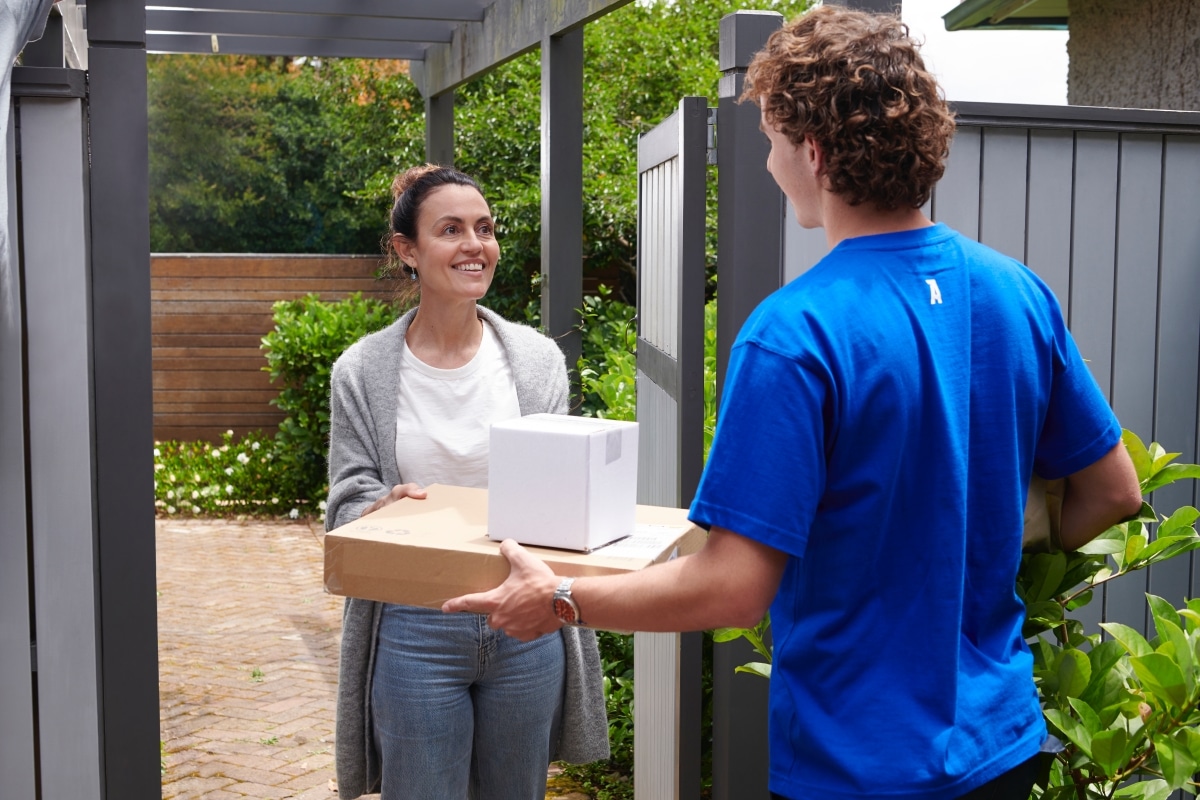 A courier delivering several parcels to recepient.