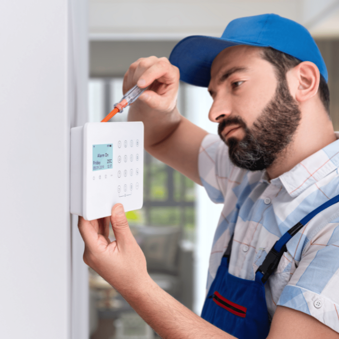 a handyperson installing a smart alarm