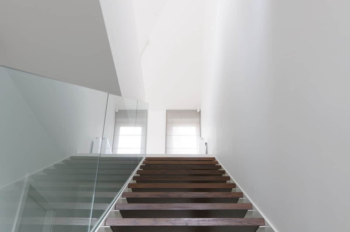 wooden staircase with glass railing