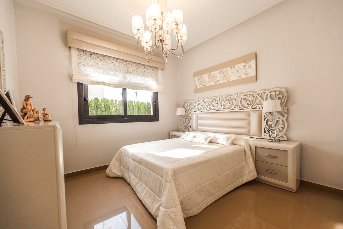 Bed with white intricately detailed headboard