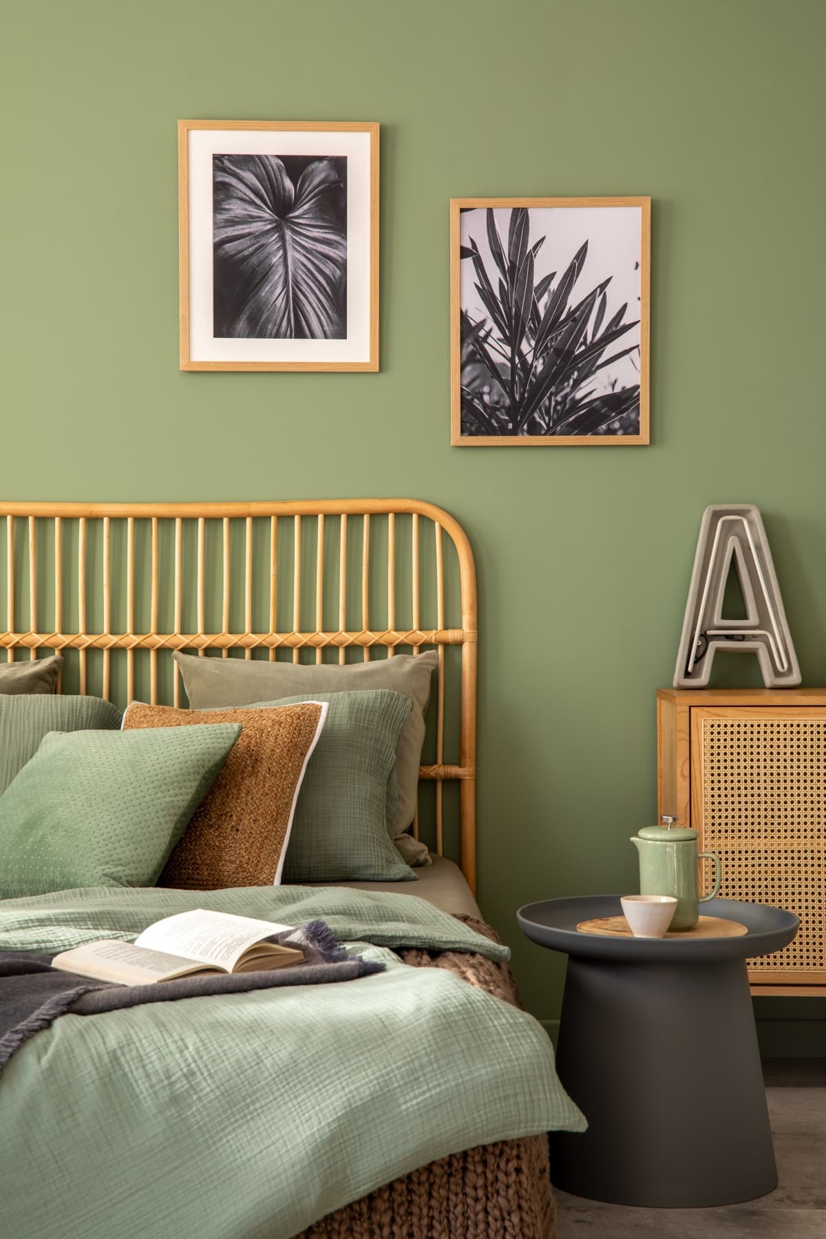 Elegant bedroom interior design with mock up poster frames, bamboo bed, modern bedclothes, side table and stylish accessories