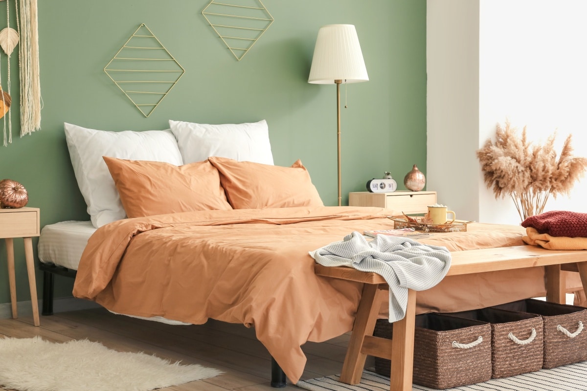 Stylish interior of room with big comfortable bed and autumn decor
