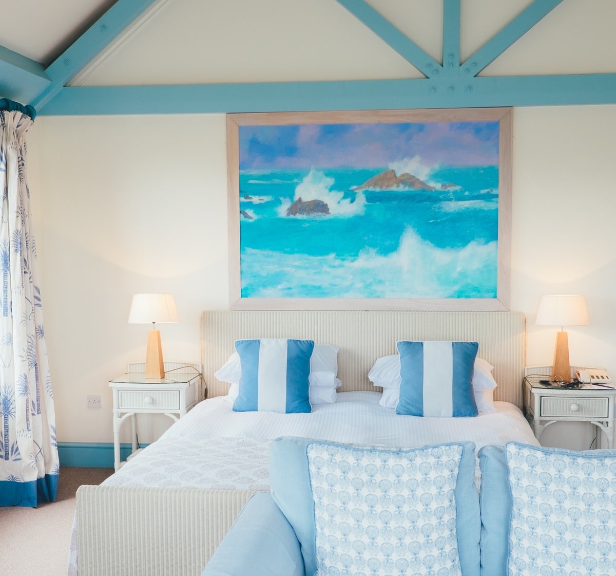 Blue themed bedroom with a patterned bedding and pillows on the bed