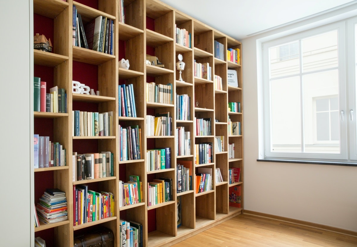 brown wooden shelf with individually arranged compartments near window