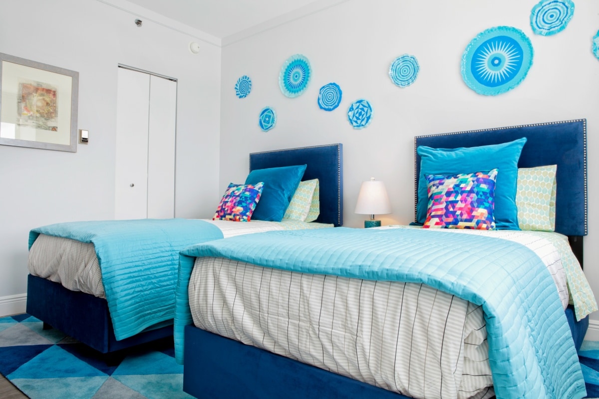White and blue linen beds sharing a room
