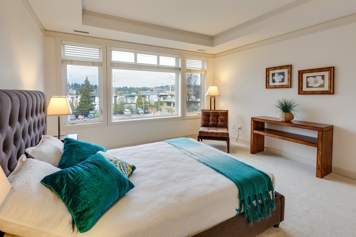 Two green and white pillows on empty bed