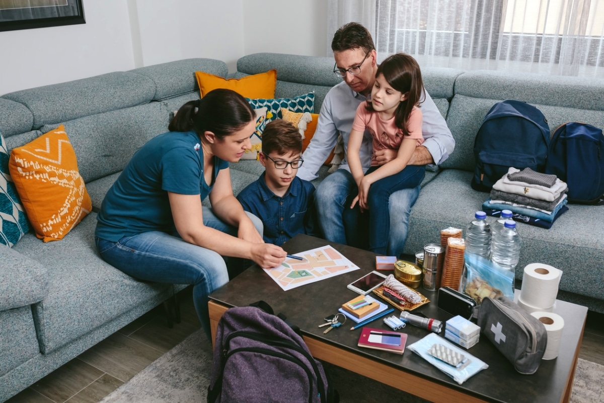 Mother explaining their bushfire survival plan to her family whilst preparing emergency backpacks.