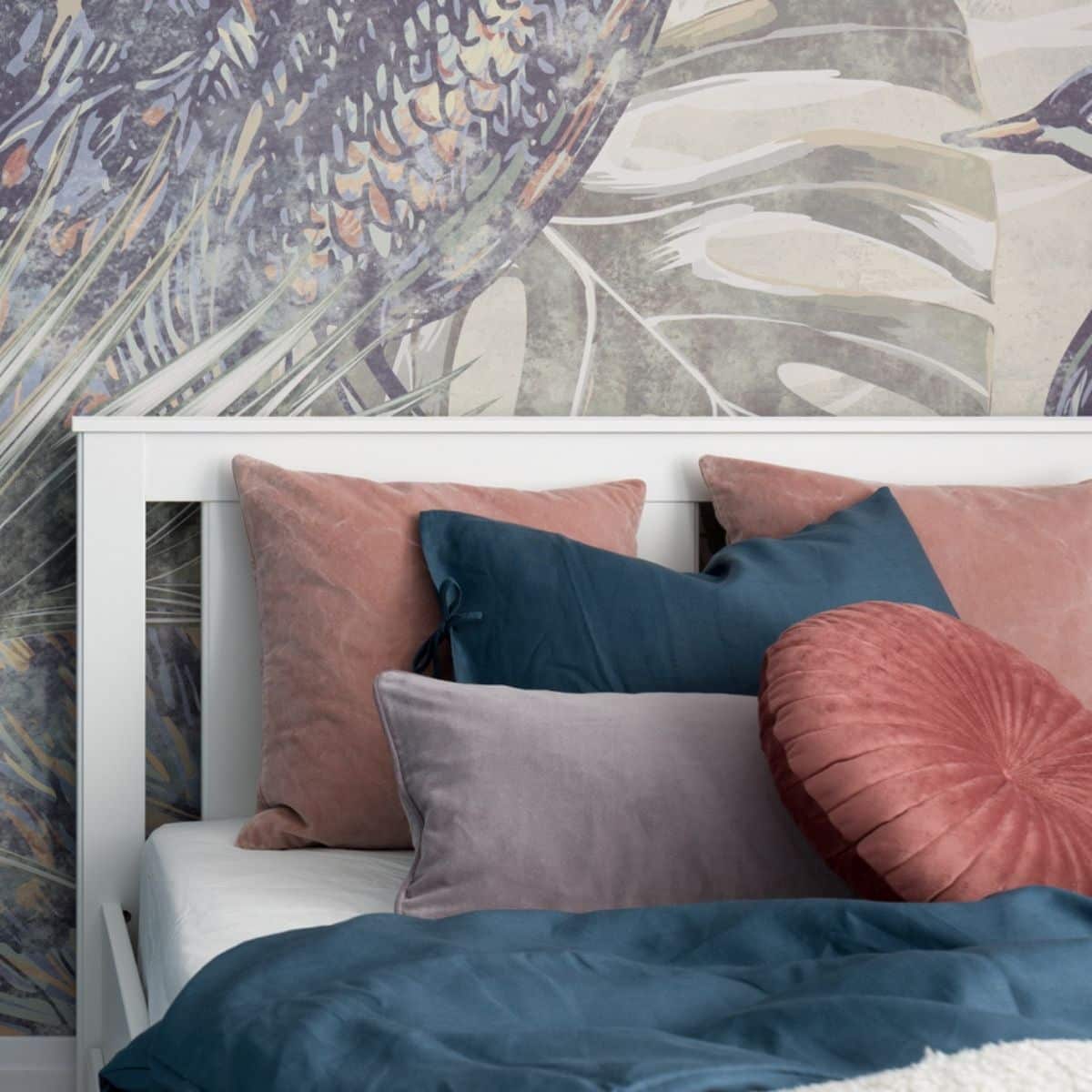 A bed with pink and teal pillows, and a teal-colored blanket