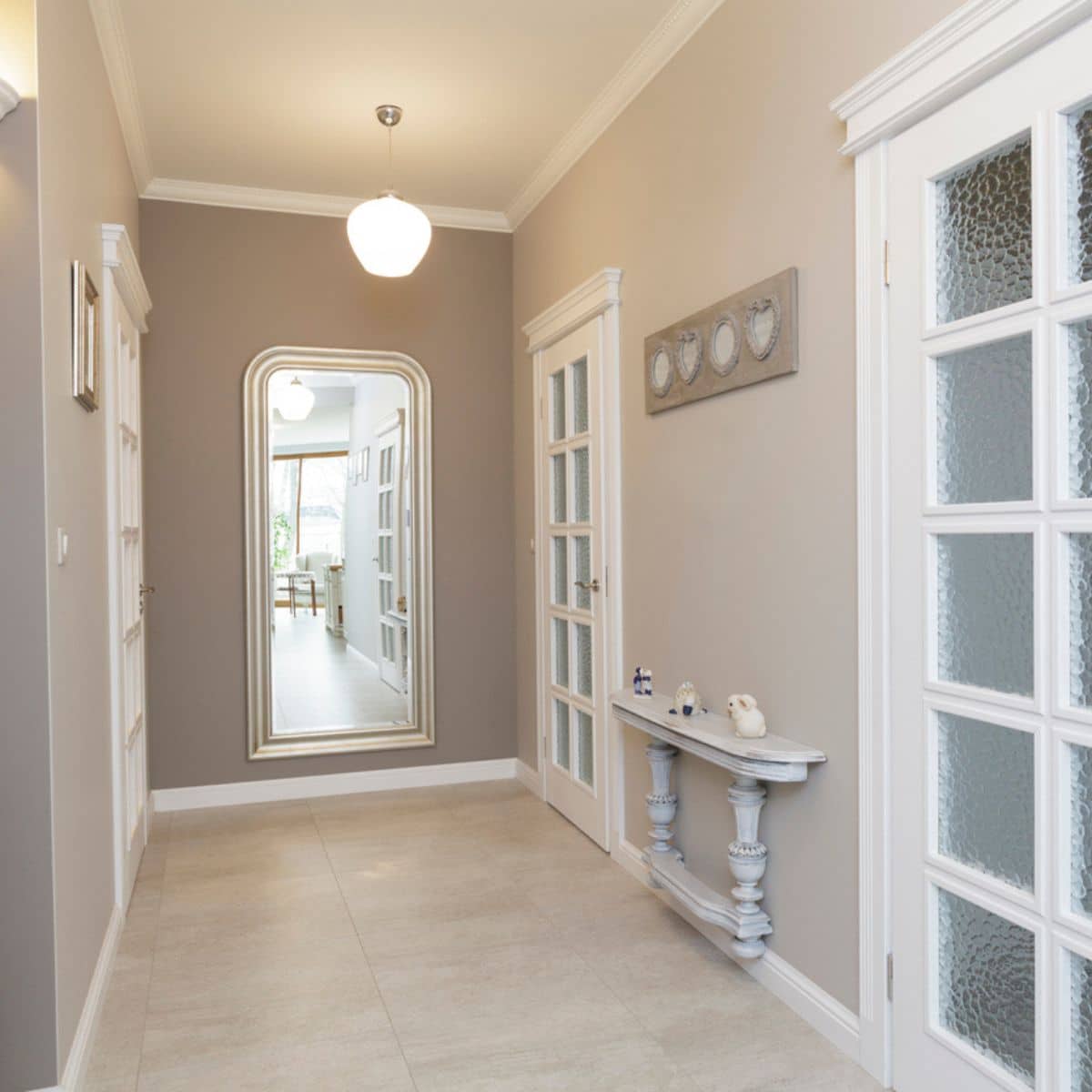 an arched mirror at the end of a hallway