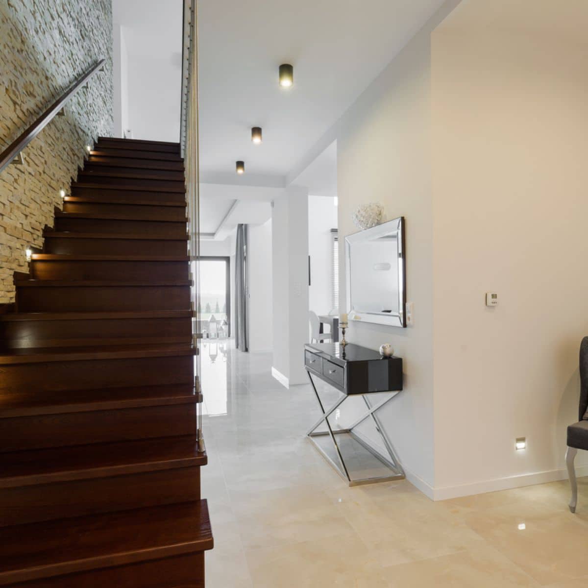 a modern long hallway with a staircase on the side