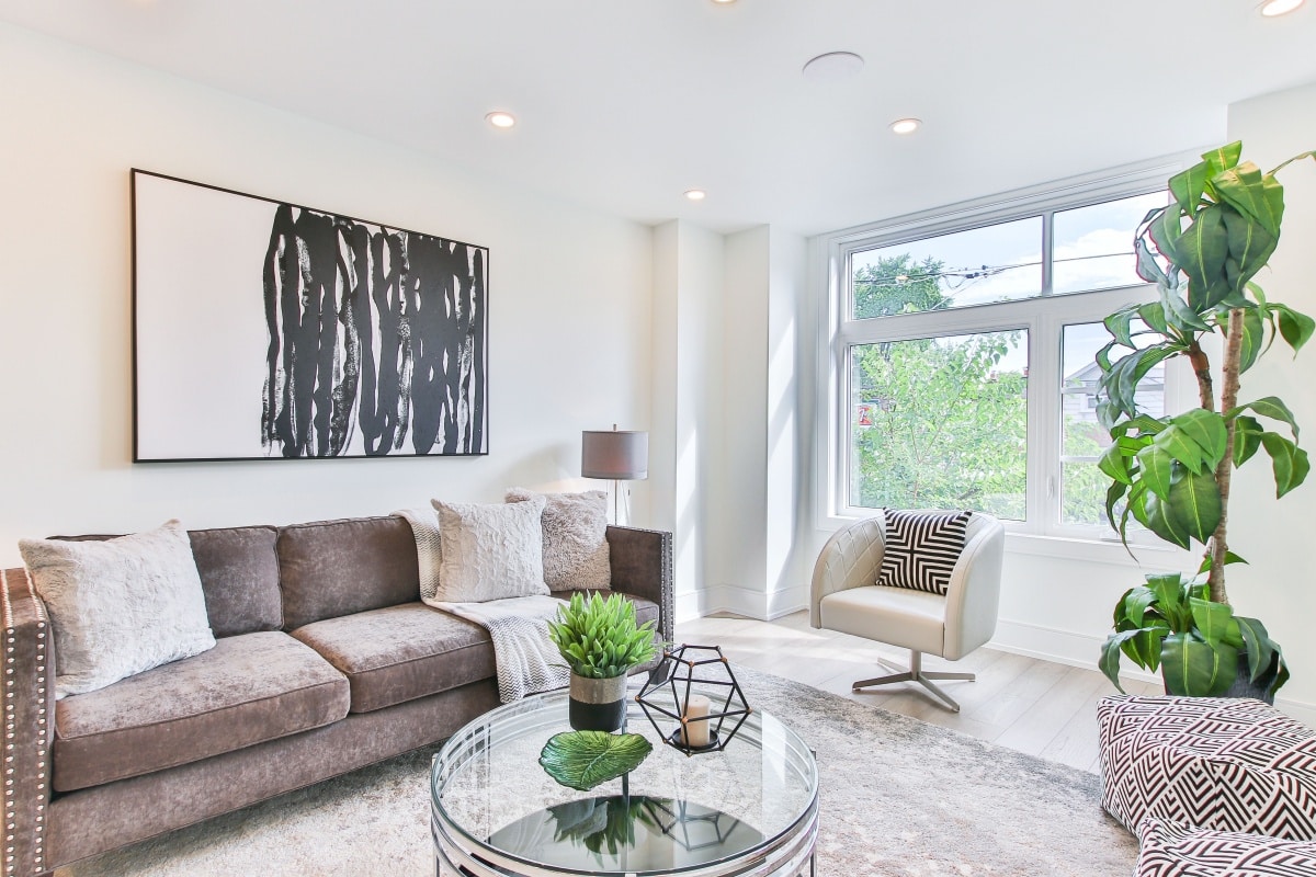 brown fabric sofa set in a bright room with white framed windows