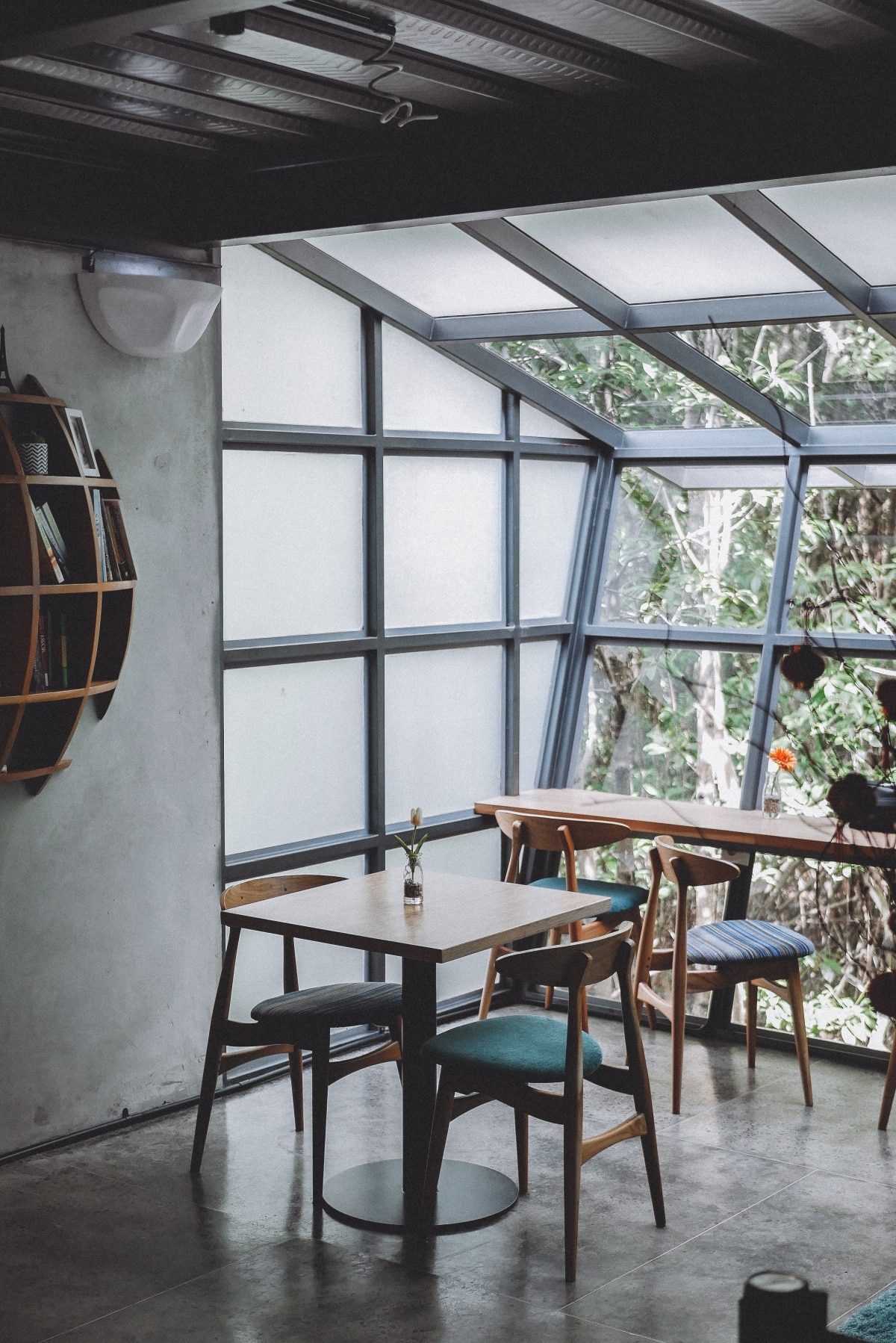 Room with tables, chairs, and a slanted window