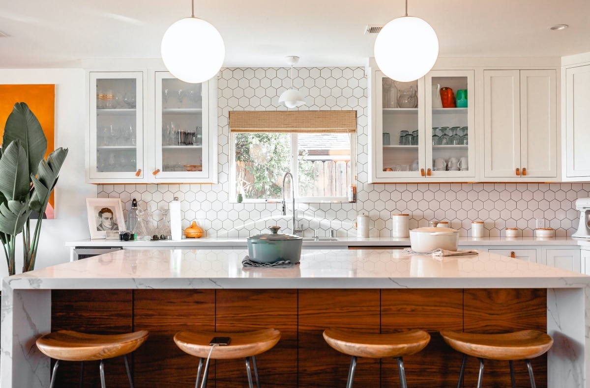 Four wooden stools in front of a kitchen island