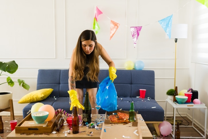 A woman cleaning the living room after a party.