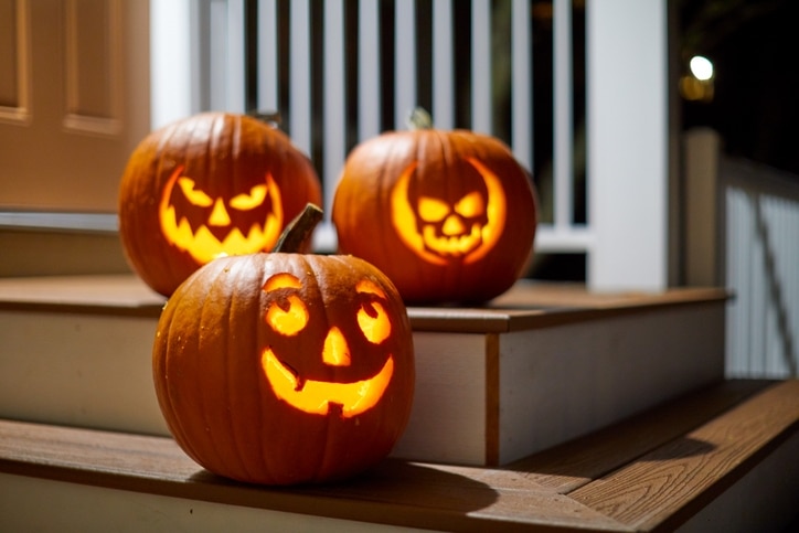Three Halloween Jack-o'-lantern pumpkins lit insight on a porch