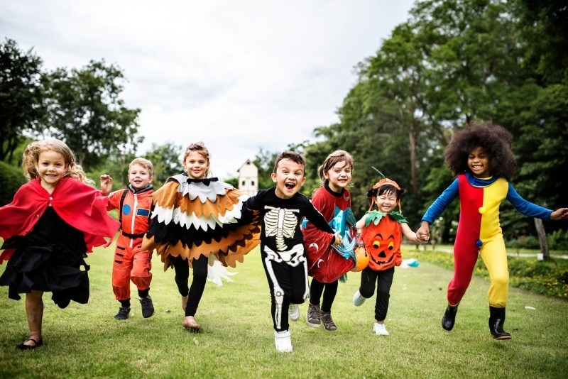 Young children wearing Halloween costumes and having fun at a party.