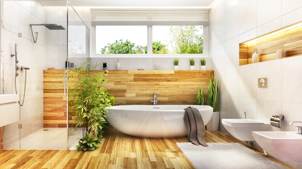 Modern spa-like bathroom featuring a freestanding bathtub, wood paneling, indoor plants, a glass-enclosed shower, and large windows with natural light.