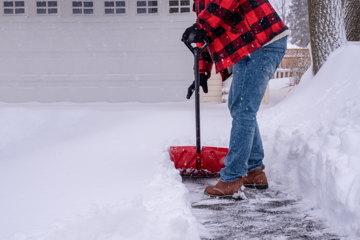 Man shoveling the driveway after a heavy snowfall.